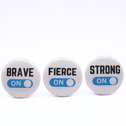 BooBooRoo Pinback Button (i.e. button, badge, pin) 3-pack displaying brave, fierce, and strong modes are on. Blue background for mode indicator.