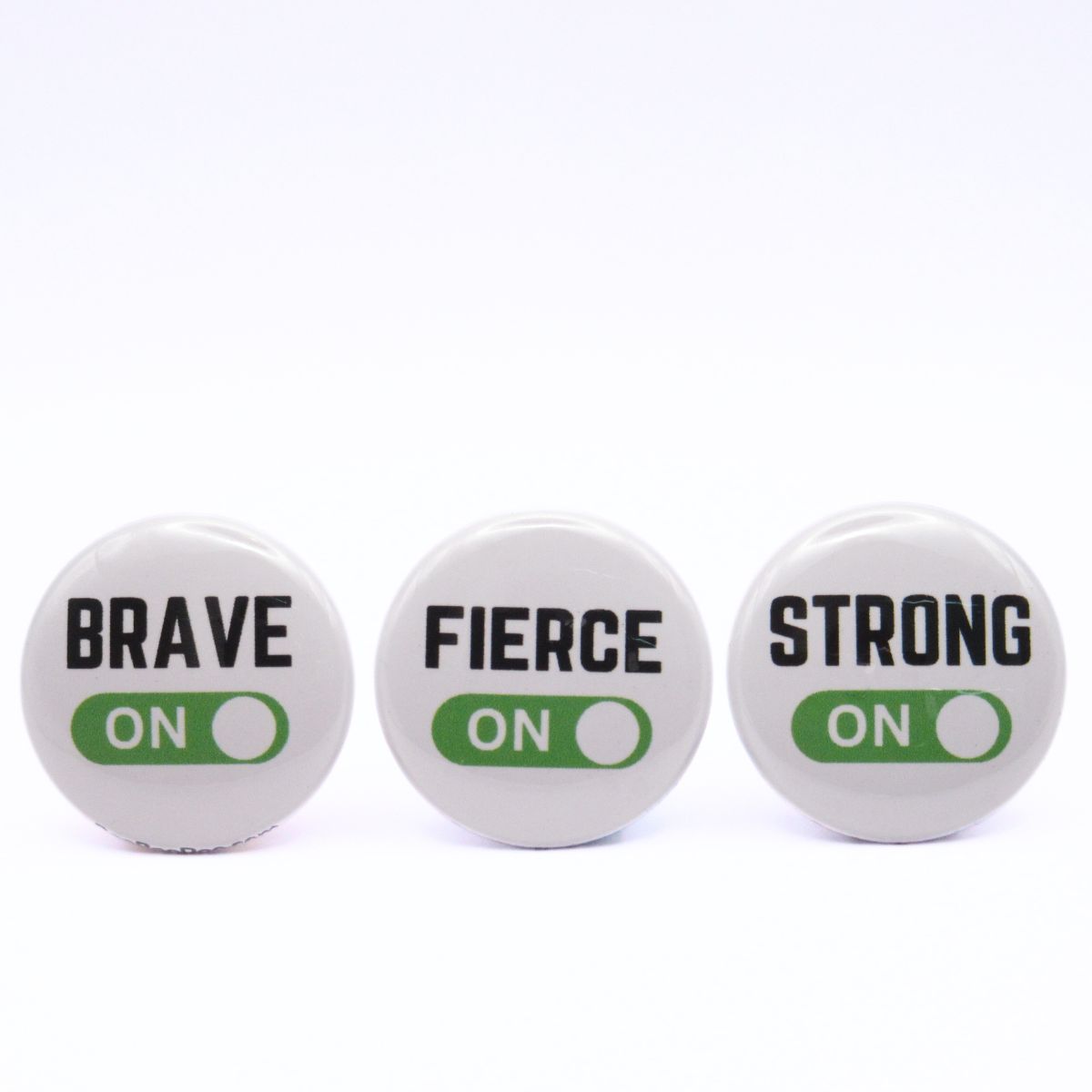 BooBooRoo Pinback Button (i.e. button, badge, pin) 3-pack displaying brave, fierce, and strong modes are on. Green background for mode indicator.