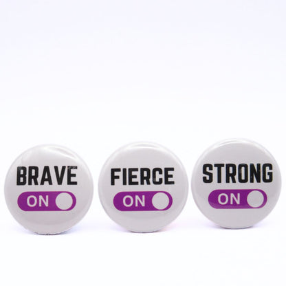 BooBooRoo Pinback Button (i.e. button, badge, pin) 3-pack displaying brave, fierce, and strong modes are on. Purple background for mode indicator.
