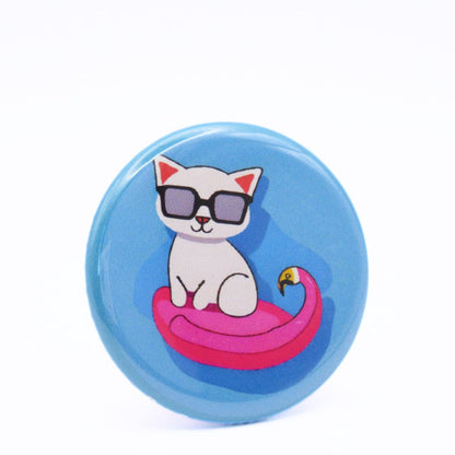 BooBooRoo Pinback Button (i.e. button, badge, pin) of a white cat wearing sunglasses sitting in a flamingo pool floatie