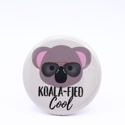 BooBooRoo Pinback Button (i.e. button, badge, pin) of the face of a koala wearing wayfarer sunglasses with the saying, "Koala-fied cool."