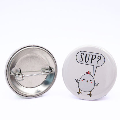 BooBooRoo Pinback Button (i.e. button, badge, pin) of a Cute Kawaii style Chicken Saying "Sup?". Image showing front and back of high-quality metal button.